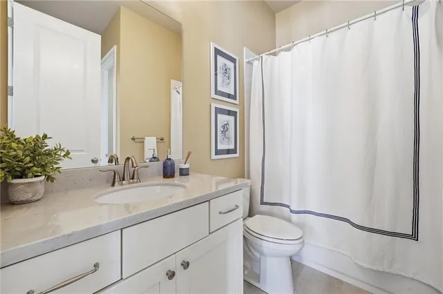 a bathroom with a granite countertop sink mirror vanity and toilet