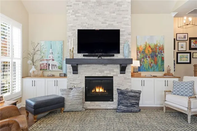 a living room with furniture a flat screen tv and a fireplace