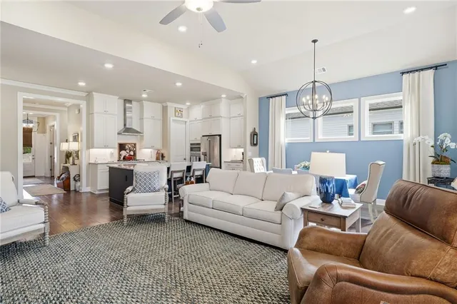 a living room with furniture kitchen view and a chandelier