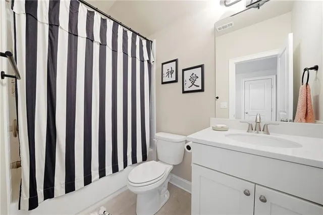 a bathroom with a sink a toilet and shower curtain