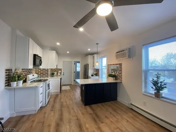 a kitchen with stainless steel appliances kitchen island granite countertop a stove and a sink