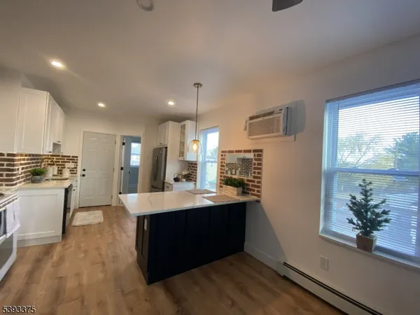 a kitchen with kitchen island sink stove and refrigerator