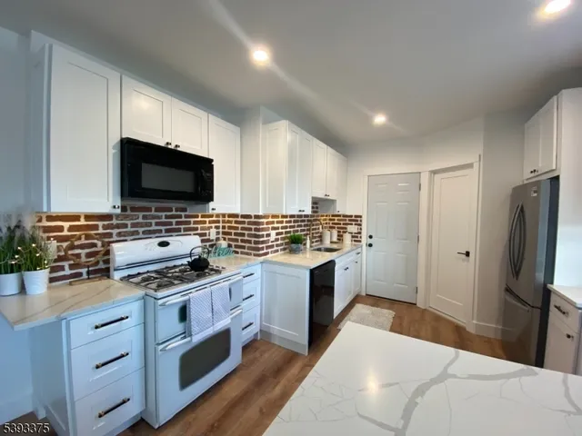 a kitchen with stainless steel appliances a stove a sink and a microwave