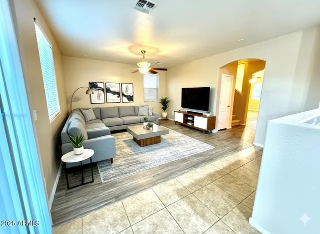 a view of a big room with wooden floor and a ceiling fan