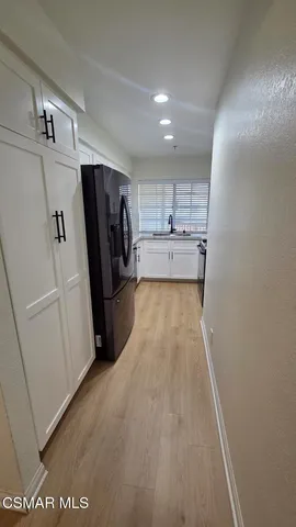 a view of a refrigerator in kitchen and wooden floor