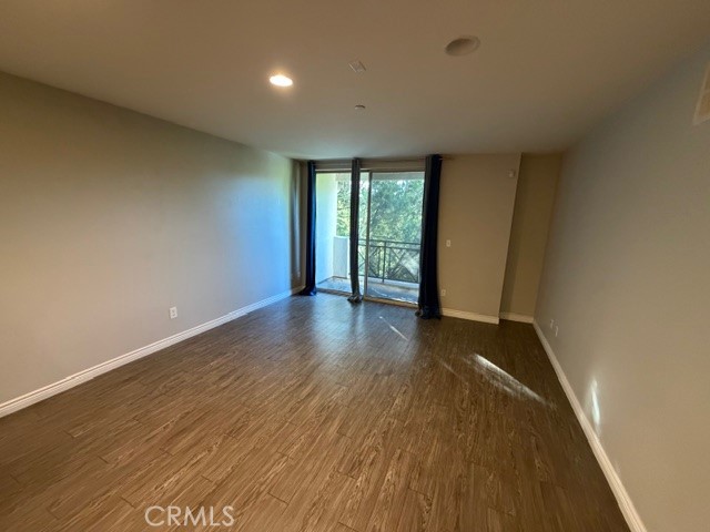 712 East Walnut Street, Unit 306 Pasadena, CA 91101 - Photo 5 of 8 a view of an empty room with wooden floor and a window