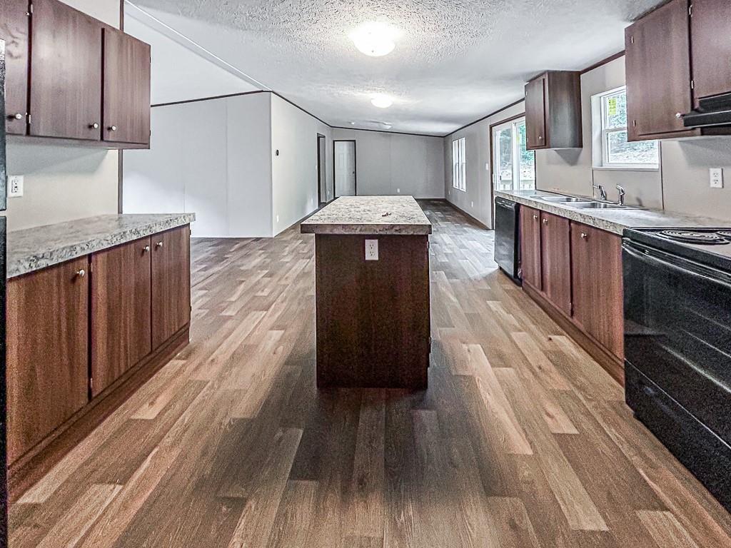 564 Ridge Road Dawsonville, GA 30534 - Photo 4 of 25 a kitchen with granite countertop wooden floors wooden cabinets and stainless steel appliances