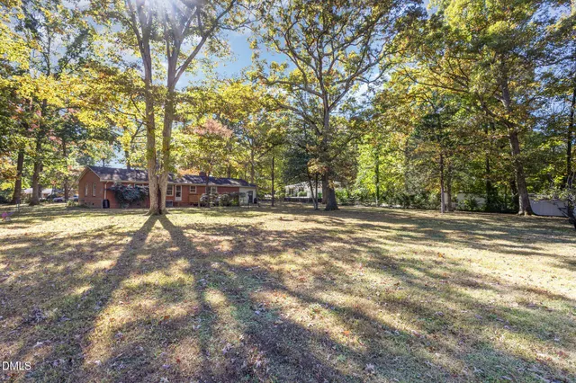 a view of a house with a yard and large tree