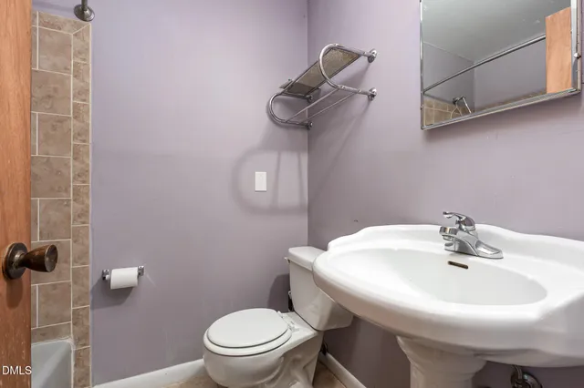 a bedroom with a bed a chair and computer on the desk