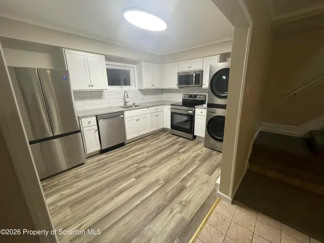 a kitchen with a sink a refrigerator a stove top oven and cabinets