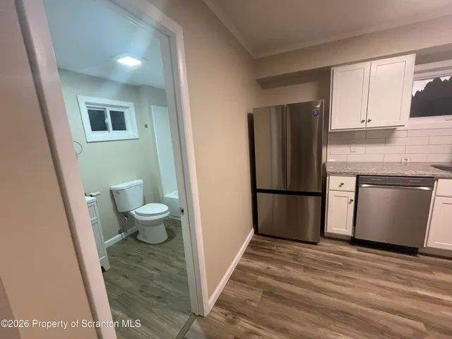 a bathroom with a toilet sink vanity tub and shower
