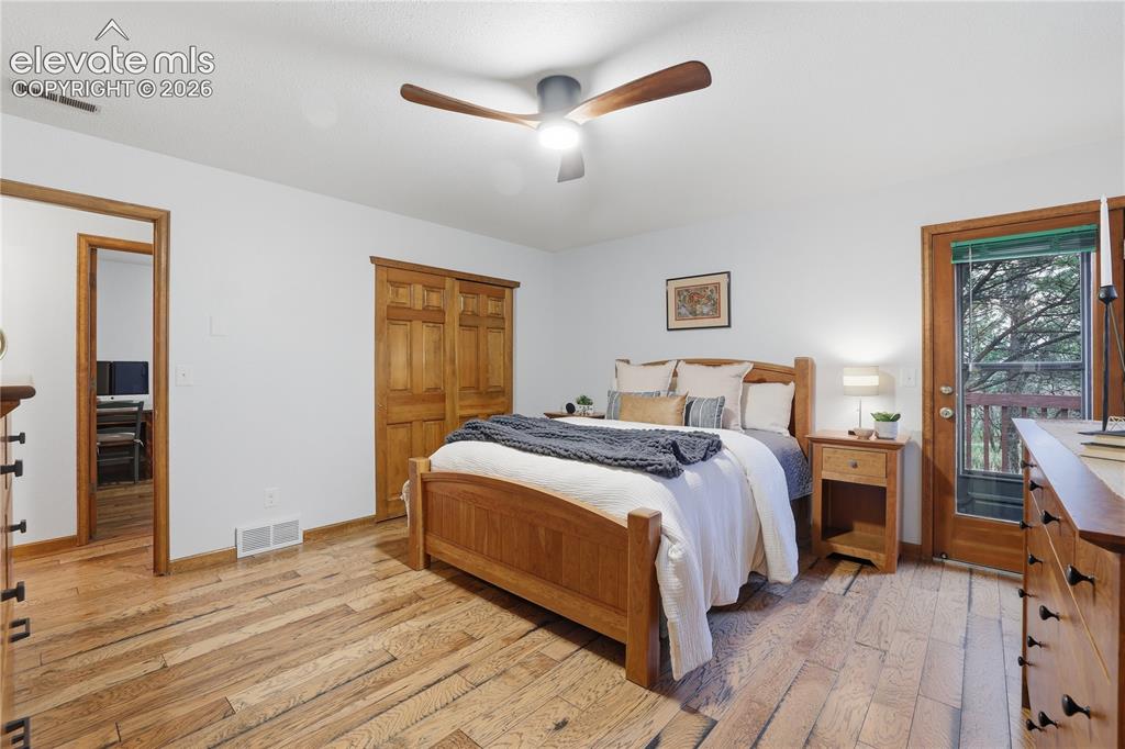 18190 Forest View Road Monument, CO 80132 - Photo 20 of 50 a bedroom with a bed and wooden floor