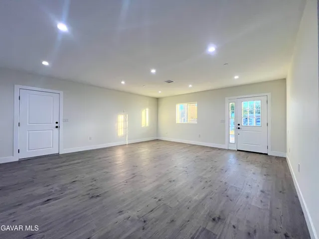 a large kitchen with a lot of counter space and wooden floor