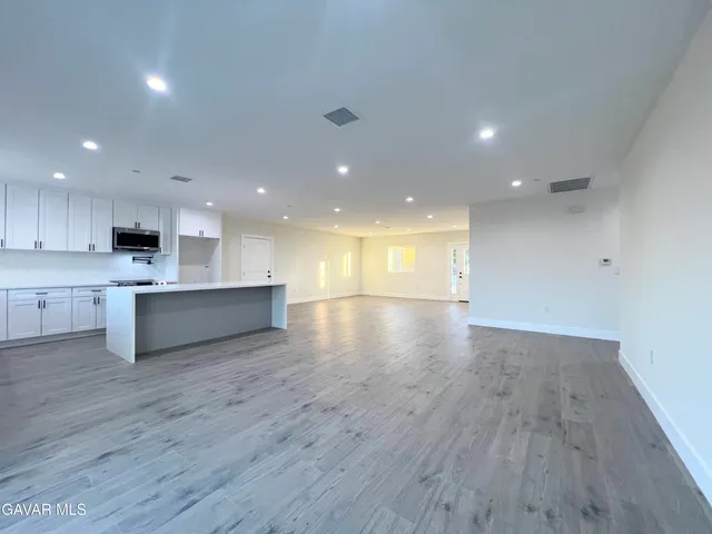 a kitchen with stainless steel appliances a stove microwave and sink