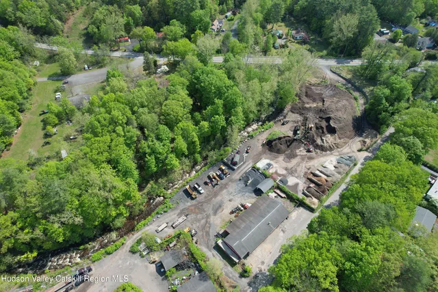 an aerial view of residential house with outdoor space and trees all around