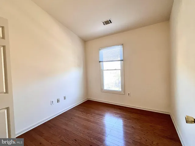 an empty room with wooden floor and window