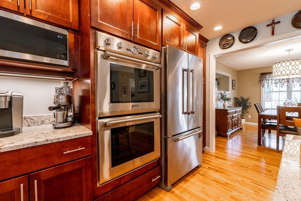 22 Duluth Street Worcester, MA 01604 - Photo 5 of 35 a kitchen with stainless steel appliances granite countertop a refrigerator a stove and a microwave oven with wooden floor