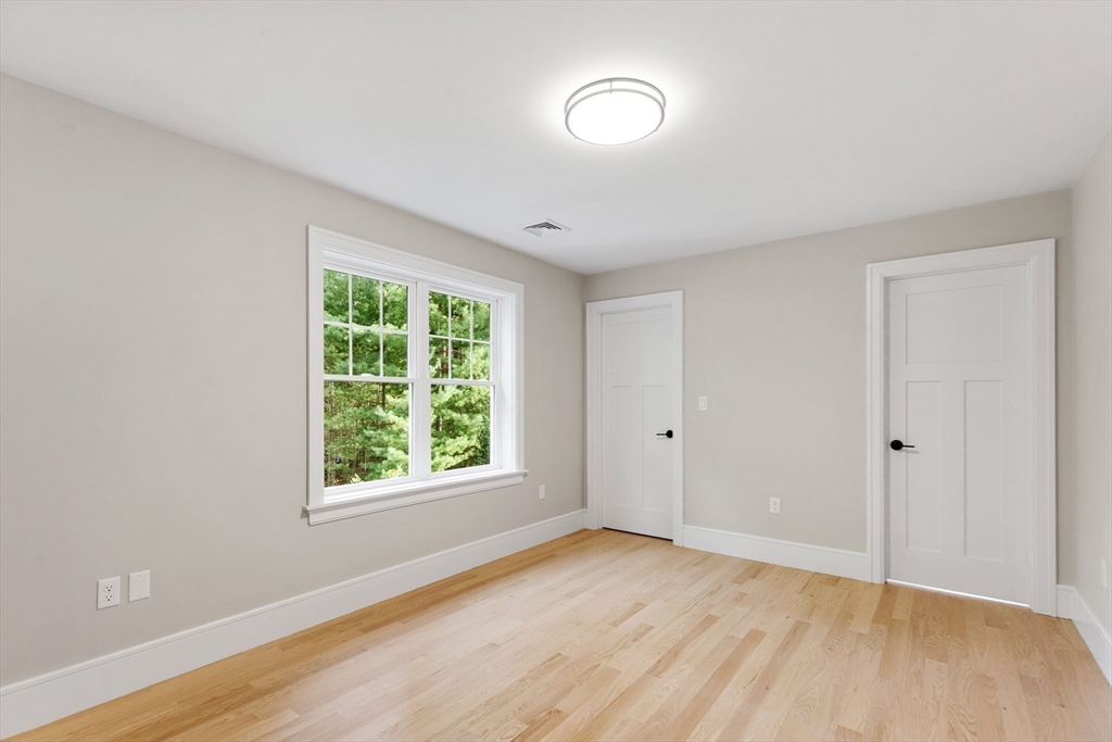 12 Pleasant Street Burlington, MA 01803 - Photo 21 of 30 a view of an empty room with wooden floor and a window