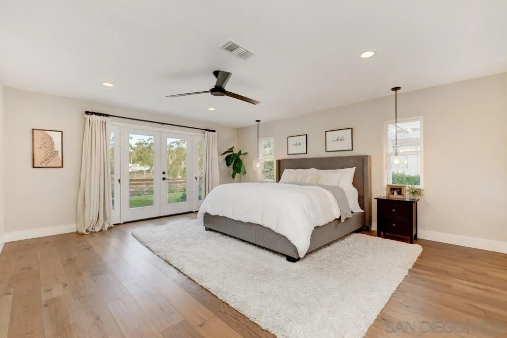 9944 Connell Road San Diego, CA 92131 - Photo 11 of 25 a bedroom with a large bed and a large window