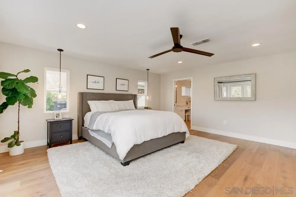 9944 Connell Road San Diego, CA 92131 - Photo 12 of 25 a spacious bedroom with a large bed and a potted plant