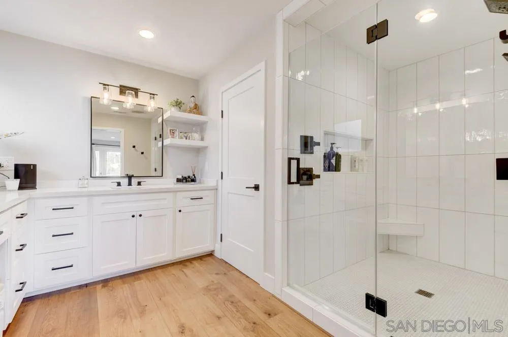 9944 Connell Road San Diego, CA 92131 - Photo 15 of 25 a bathroom with a double vanity sink mirror and shower