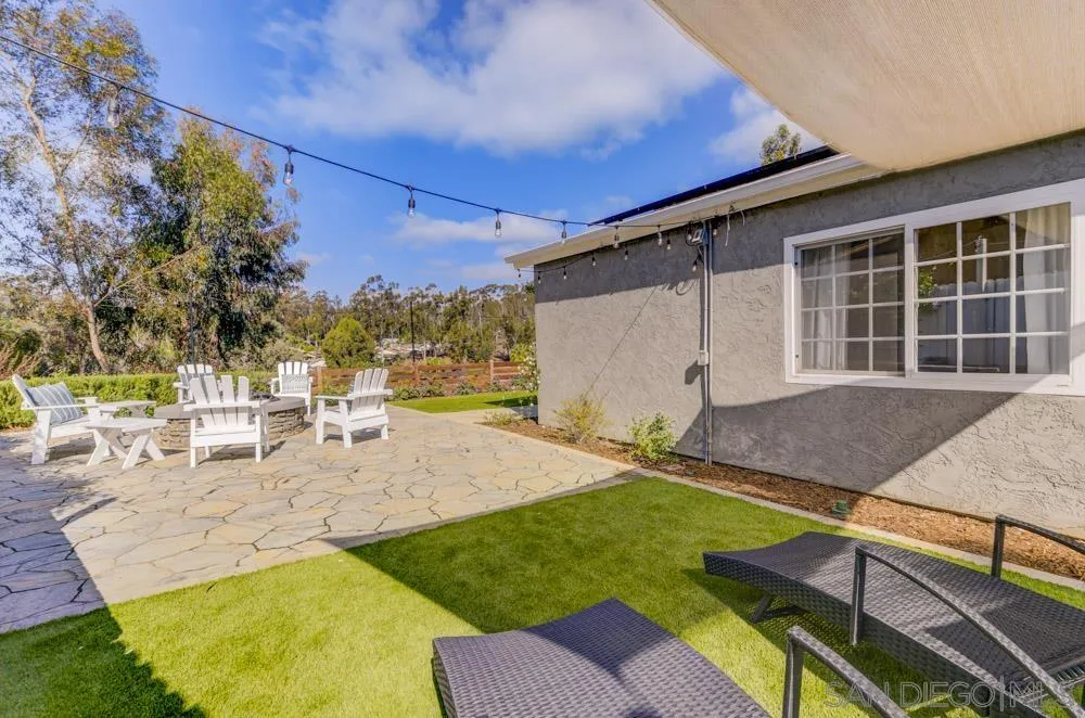 9944 Connell Road San Diego, CA 92131 - Photo 21 of 25 a view of a backyard with table and chairs under an umbrella