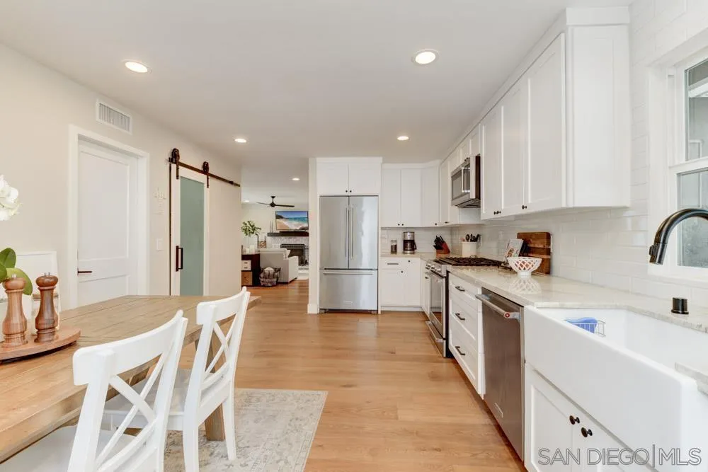 9944 Connell Road San Diego, CA 92131 - Photo 9 of 25 a kitchen with stainless steel appliances granite countertop a refrigerator sink and cabinets