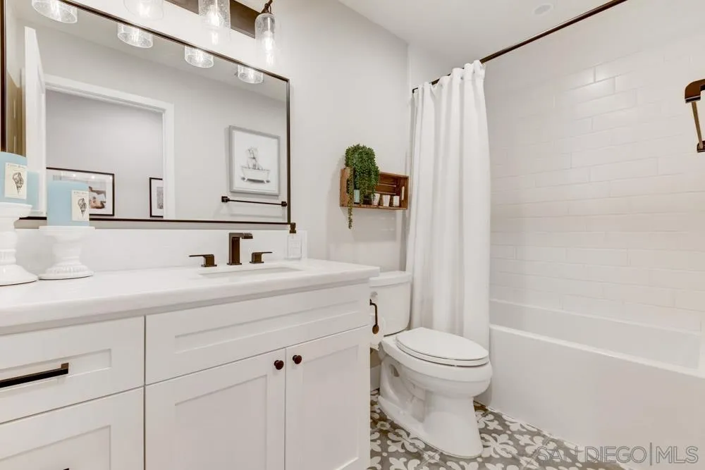 9944 Connell Road San Diego, CA 92131 - Photo 10 of 25 a bathroom with a sink a toilet and a mirror