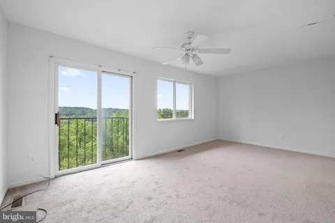 a view of empty room with wooden floor and window