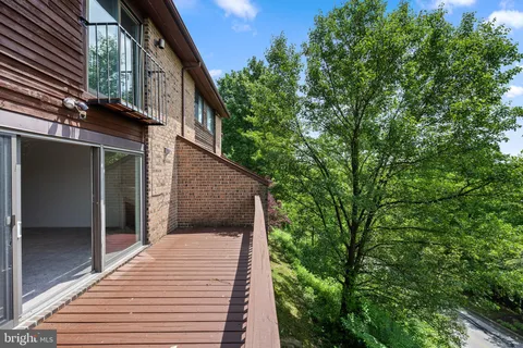 a view of an empty room with wooden floor fireplace and a window