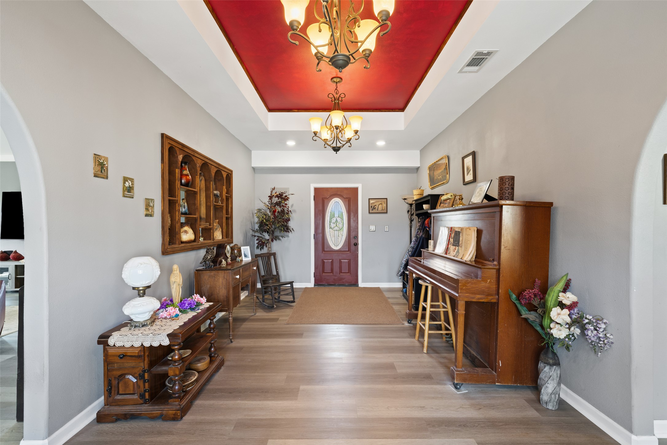 2966 Rm 165 Dripping Springs Dripping Springs, TX 78620 - Photo 17 of 23 Foyer featuring wood-finish flooring, a tray ceiling with recessed lighting, an arched doorway, and a red front entry door with an oval stained-glass insert