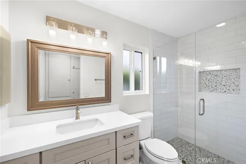 a bathroom with a sink a toilet and shower