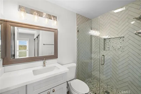 a bathroom with a sink vanity mirror and toilet