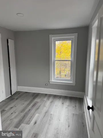 an empty room with wooden floor and a window