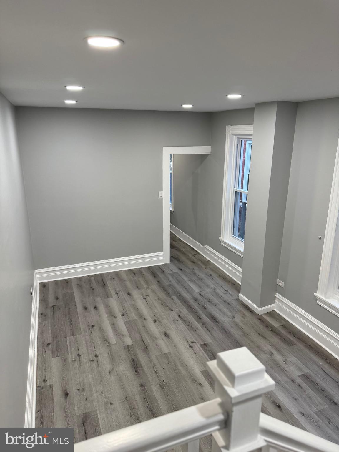 521 Windsor Street Reading, PA 19601 - Photo 8 of 14 an empty room with wooden floor and windows