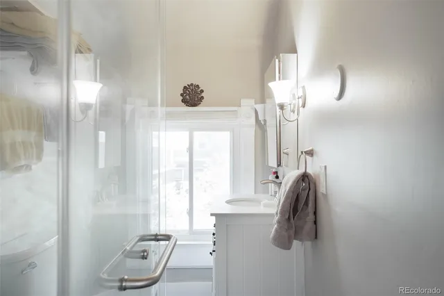 a bathroom with a granite countertop sink a toilet a vanity and mirror