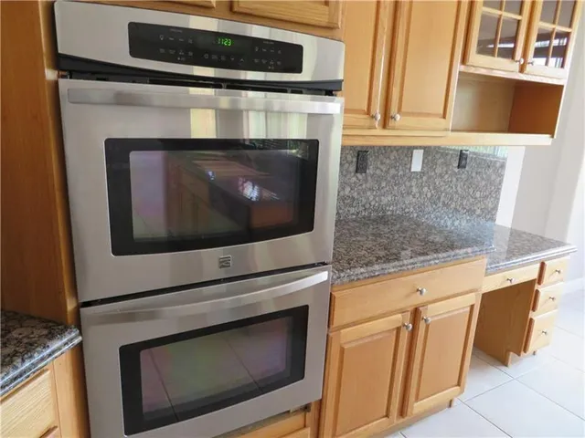 a bathroom with a granite countertop sink and a large mirror