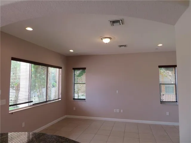 an empty room with a window and a fan