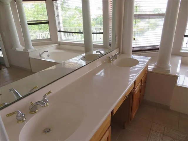 a large bathroom with a large tub and sink