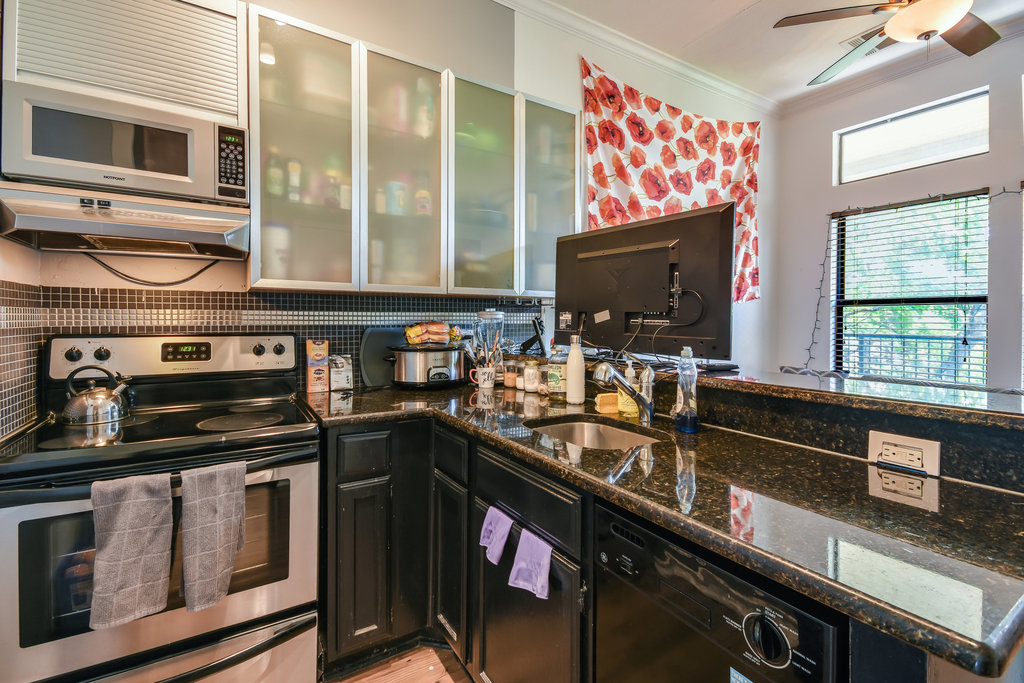 2802 Nueces Street, Unit 307 Austin, TX 78705 - Photo 11 of 16 a kitchen with stainless steel appliances a stove sink and microwave