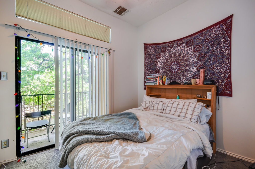2802 Nueces Street, Unit 307 Austin, TX 78705 - Photo 14 of 16 a bedroom with a bed and a painting on the wall