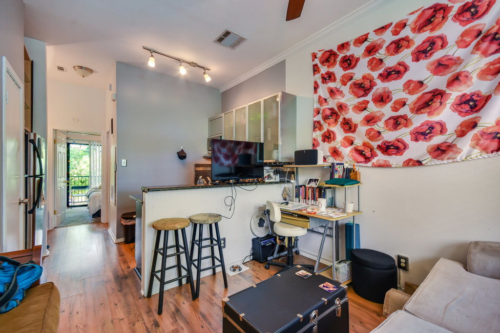 2802 Nueces Street, Unit 307 Austin, TX 78705 - Photo 8 of 16 a room with stainless steel appliances a dining table wooden floor and a large window