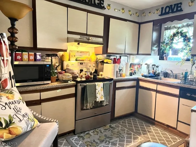 a kitchen with stainless steel appliances granite countertop a sink and cabinets