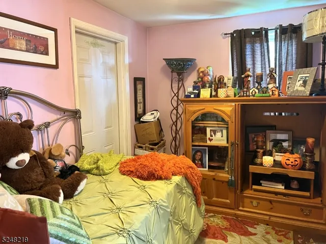 a bedroom with a bed and a flat tv screen on the dresser