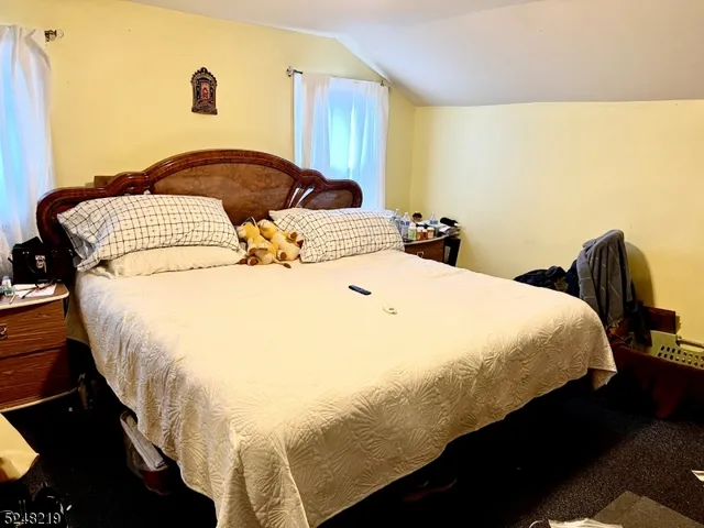 a large bed sitting in a bedroom next to a window