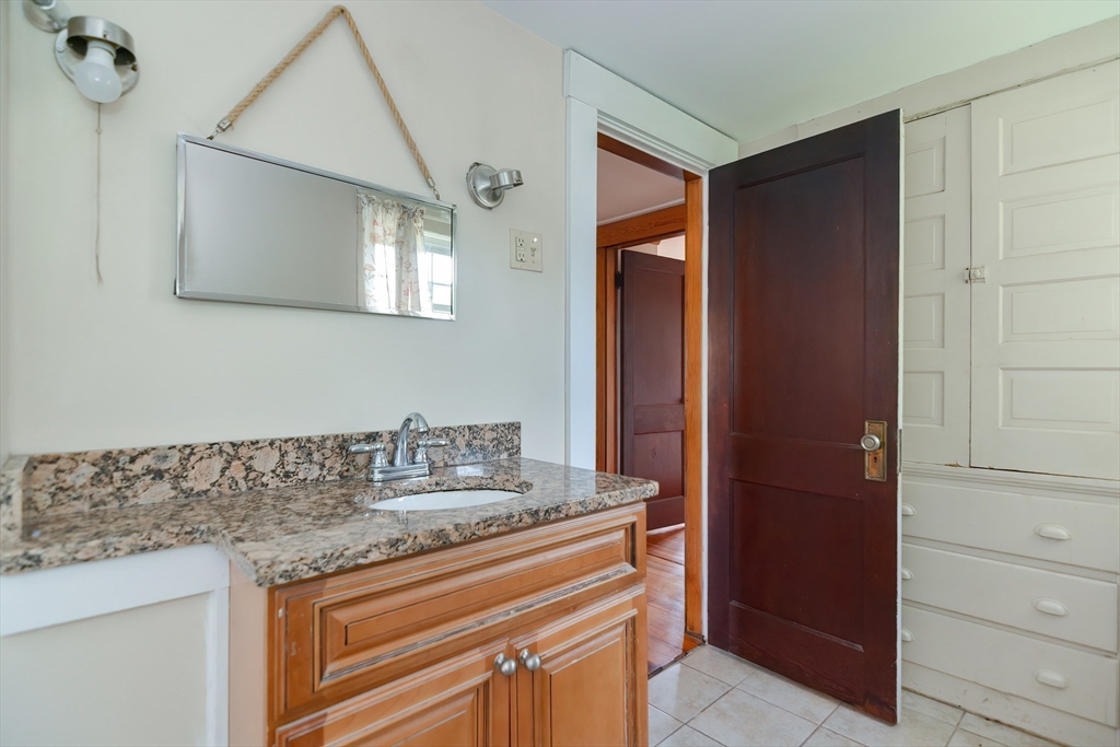 2 Prospect Street Milford, MA 01757 - Photo 27 of 31 a bathroom with a granite countertop sink and a mirror