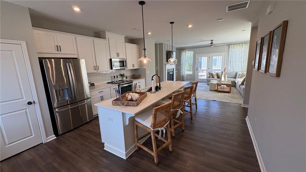 600 Tiller Way Acworth, GA 30102 - Photo 5 of 23 a kitchen with stainless steel appliances granite countertop a refrigerator a stove a sink dishwasher and a dining table with wooden floor