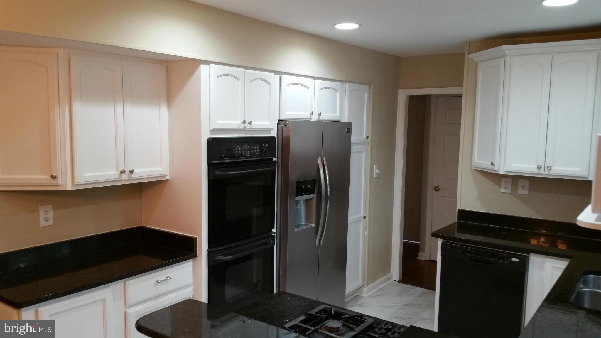 12408 Starlight Lane Bowie, MD 20715 - Photo 15 of 26 a kitchen with a refrigerator stove and cabinets