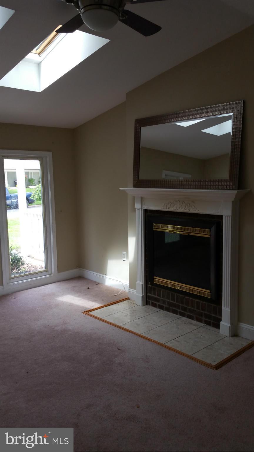12408 Starlight Lane Bowie, MD 20715 - Photo 22 of 26 a living room with a fireplace and a flat screen tv