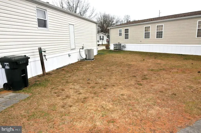 a view of a white house with a yard and sitting area